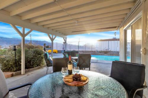 a table with wine glasses and a plate of food at 6 Mi to Joshua Tree Home with Outdoor Oasis and View! in Twentynine Palms