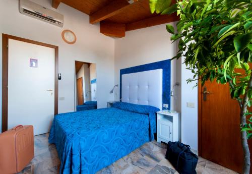Un dormitorio con una cama azul y una planta en Hotel Caselle, en San Lazzaro di Savena