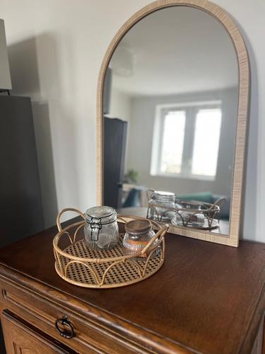 a wicker basket on top of a dresser with a mirror at Évasion in Marmande