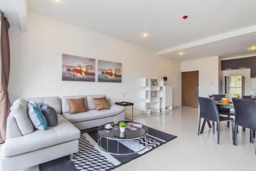 a living room with a couch and a table at Chic Condo by RESAVA in Karon Beach