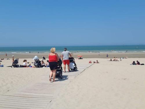 a group of people walking on the beach at Ti Malo - studio proche plage Dunkerque in Dunkerque