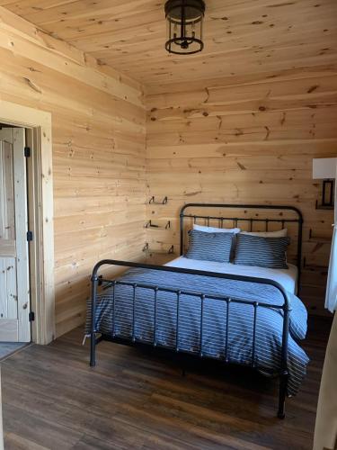 a bedroom with a bed in a wooden wall at Sunshine Hill in Fairview