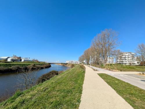 a walkway next to a river with a road at Ti Malo - studio proche plage Dunkerque in Dunkerque