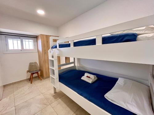 a bedroom with two bunk beds with blue sheets at Larnaca BeachHouse in Larnaka