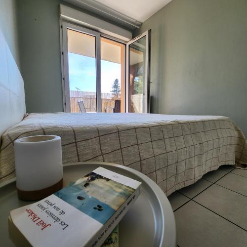 - une chambre avec un lit et un livre sur une table dans l'établissement Appartement au calme à NICE à proximité de tout !, à Nice