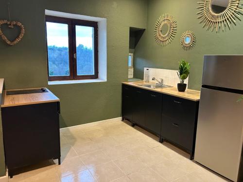 a kitchen with a sink and a refrigerator at Love Room Au domaine Insolite in Parnans