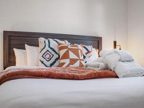 a bed with many pillows on top of it at Coler House Cyclist Retreat with Hot Tub in Bentonville