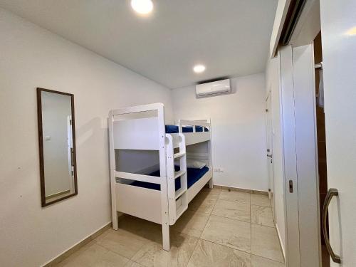 a room with a bunk bed and a mirror at Larnaca BeachHouse in Larnaka