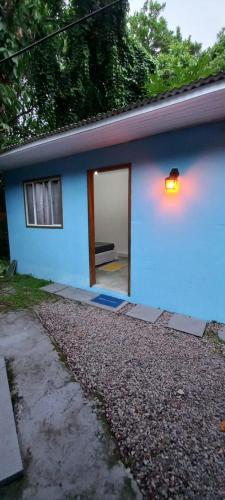 a blue house with a light on the side of it at Camping e Pousada do Ade in Ilha do Mel