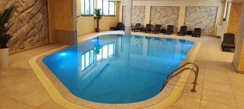una gran piscina en un hotel con sillas alrededor en Planinski Biser - Spa & Lux Apartment, en Zlatibor