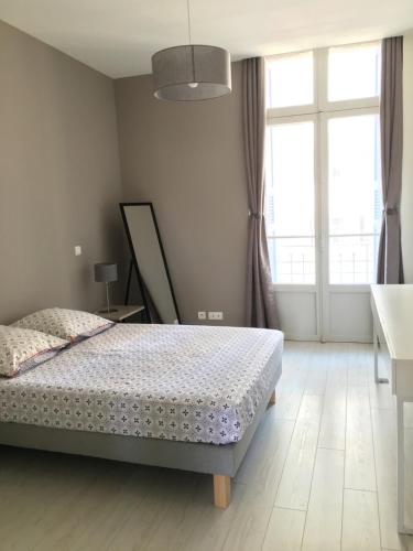 une chambre avec un lit et une grande fenêtre dans l'établissement T3 City Centre bright, Balcony, near Train Station, à Perpignan