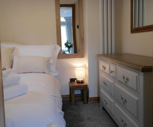a bedroom with a bed and a dresser and a mirror at Ashford House 2 bedroom Apartment 'outdoor bathing tub' in Fylingthorpe