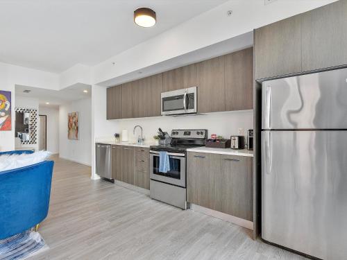 a kitchen with a stainless steel refrigerator and wooden cabinets at X Lounge III-Modern Corner Residence in Miami