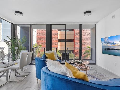 Una sala de estar con un sofá azul y una mesa. en X- Lounge III - High-Rise with Rooftop Pool & Panoramic City Views, en Miami
