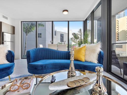 a living room with blue couches and a glass table at X Lounge III-Modern Corner Residence in Miami