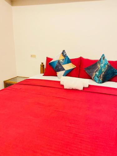a red bed with colorful pillows on it at AquaTerra Comfy stay Varkala beach in Varkala