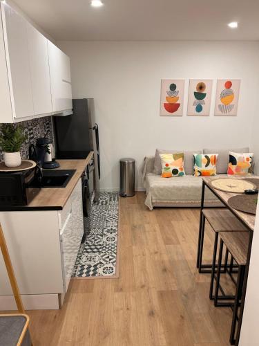 une cuisine et un salon avec un canapé dans l'établissement Évasion cosy, proche de Paris, à Argenteuil