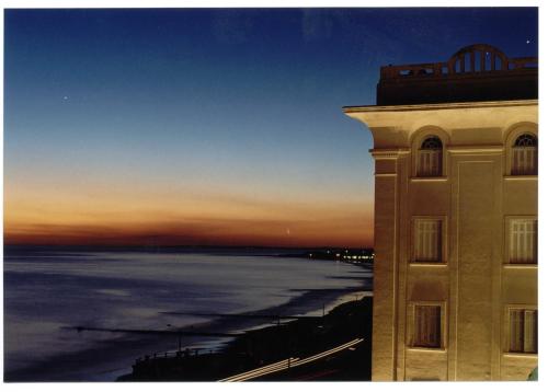 ein Gebäude mit Blick auf den Ozean bei Sonnenuntergang in der Unterkunft Argentino Hotel Casino & Resort in Piriápolis