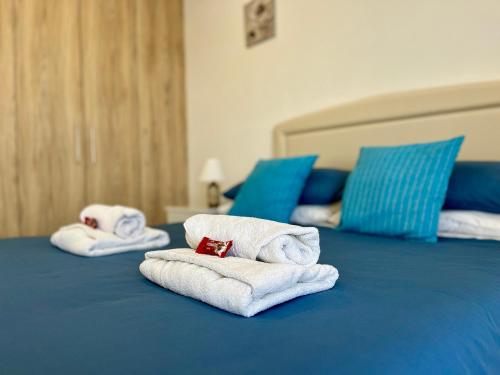 two stacks of towels on a blue bed at Larnaca BeachHouse in Larnaka