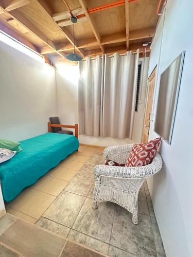 a bedroom with a bed and a couch and a chair at Doña Patty in El Tabo