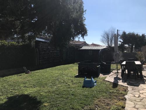 a backyard with a lawn with a table and a fence at Chez Sophie et Bernard in Saverdun