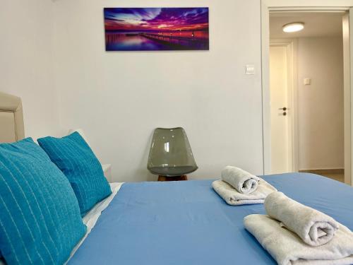 a bedroom with a blue bed with towels on it at Larnaca BeachHouse in Larnaka