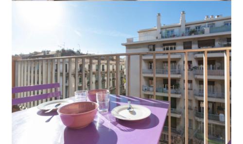 - une table avec un bol, des assiettes et des verres sur un balcon dans l'établissement Studio Nice clim wifi, à Nice