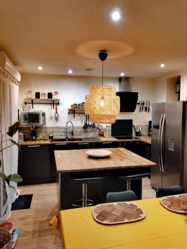 une cuisine avec des appareils noirs et une table jaune dans l'établissement Le cocon Havrais, au Havre