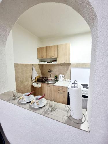 a kitchen with a table with dishes on it at Apartman Family in Sarajevo