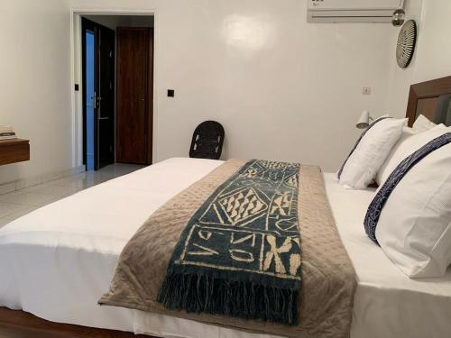 a bedroom with a bed with a blanket on it at Villa Piagne Bastos in Yaoundé