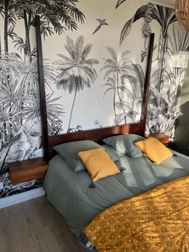 - une chambre avec un lit recouvert de palmiers dans l'établissement Villa 1920 rénovée, à Guérande