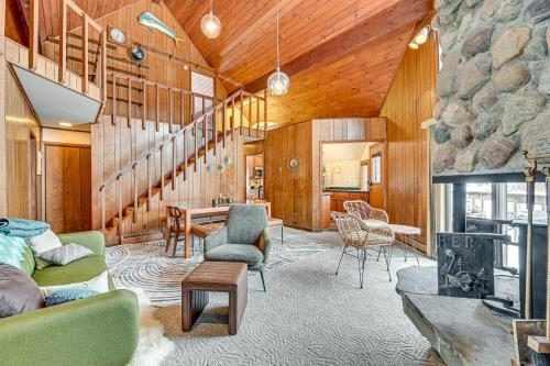 a living room with wooden walls and a stone fireplace at Near Canandaigua Lake Retro Cabin with Deck and Views in Naples