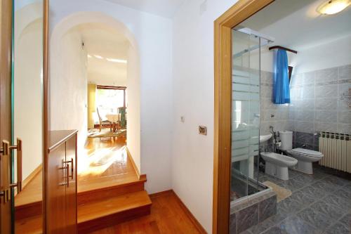 a bathroom with a toilet and a glass shower at APARTMANI GORDANA in Bibinje