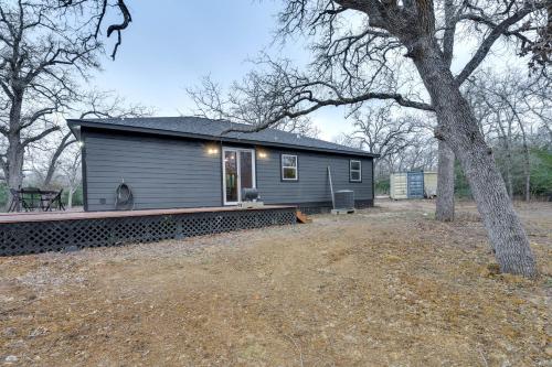a small gray house with a tree in front of it at Private Deck and Forest Setting Waelder Cabin! in Waelder