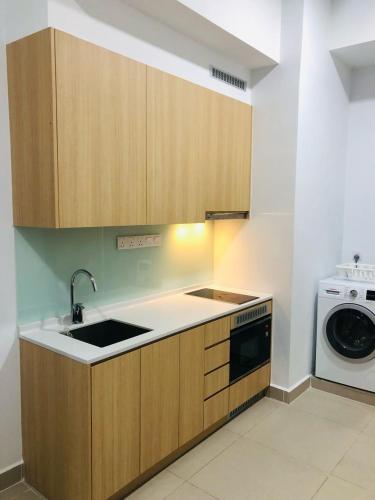 a kitchen with a sink and a washing machine at The Luxe KLCC by Homestay in Kuala Lumpur