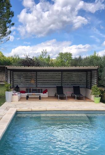 - une piscine avec 2 chaises et un banc à côté d'une maison dans l'établissement Le petit Mas, à Arpaillargues-et-Aureillac
