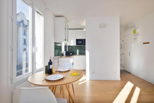 une salle à manger avec une table et une cuisine dans l'établissement Appartement lumineux proche de Paris et des transports, à Montreuil