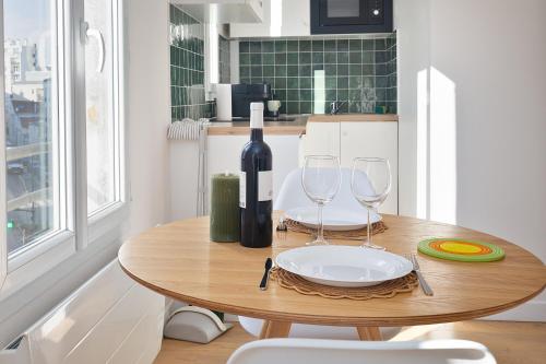 - une table avec une bouteille de vin et deux verres dans l'établissement Appartement lumineux proche de Paris et des transports, à Montreuil
