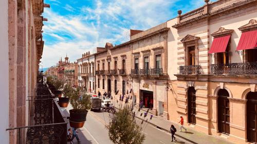 a city street with buildings and people walking down the street at Hotel Herencia By Hosting House in Morelia
