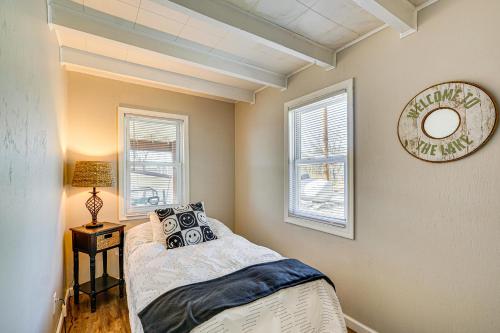 a bedroom with a bed and two windows at BBQ-Ready Home in Lake of the Ozarks State Park! in Kaiser