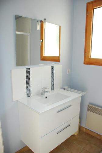 une salle de bain avec un lavabo blanc et un miroir dans l'établissement Maison en bord de mer et lisière de forêt, à La Tranche-sur-Mer
