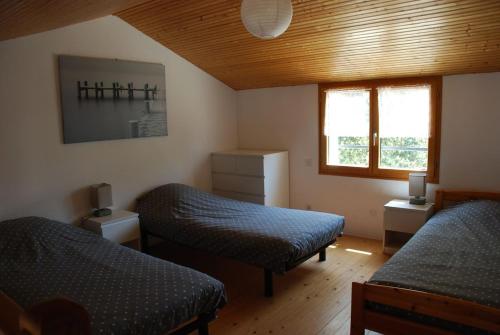 une chambre avec deux lits et une fenêtre dans l'établissement Maison en bord de mer et lisière de forêt, à La Tranche-sur-Mer