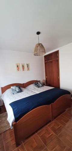 a bedroom with a large bed with a blue blanket at Buarcos Beach House in Buarcos