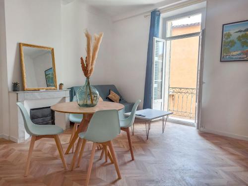 une salle à manger avec une table, des chaises et un vase dans l'établissement Lumière dorée, à Hyères