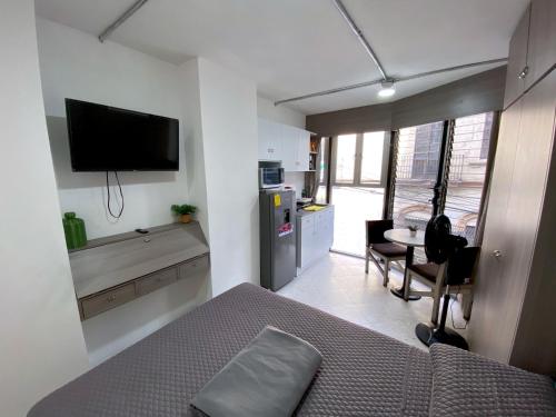 a bedroom with a bed and a kitchen with a table at Estudios by Flor y tierra in Guadalajara