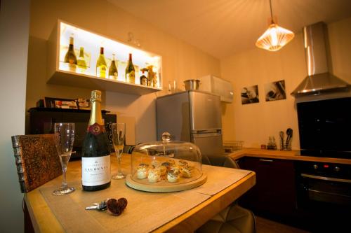 - une table avec une bouteille de vin et une assiette de nourriture dans l'établissement Suite Romantique & Spa, à Dijon