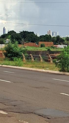a fence on the side of a road with animals at Kitnet in Campo Grande