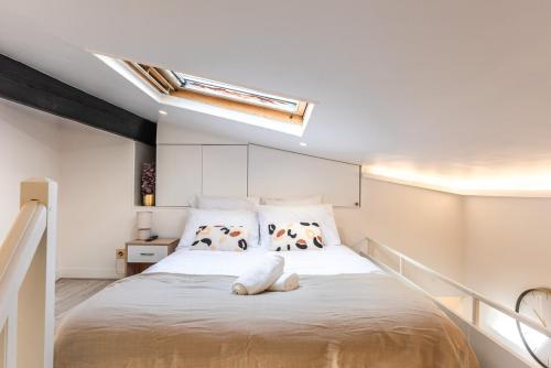 une chambre avec un grand lit dans une pièce dans l'établissement Appartement Raffiné avec Jacuzzi et AC - 6P, à Paris