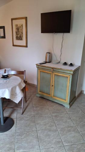 a room with a tv on a wall with a table at Casina gialla in Fabbricaccia