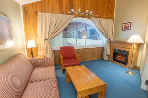 a living room with a couch and a fireplace at Fireside Inn & Suites Gilford in Gilford